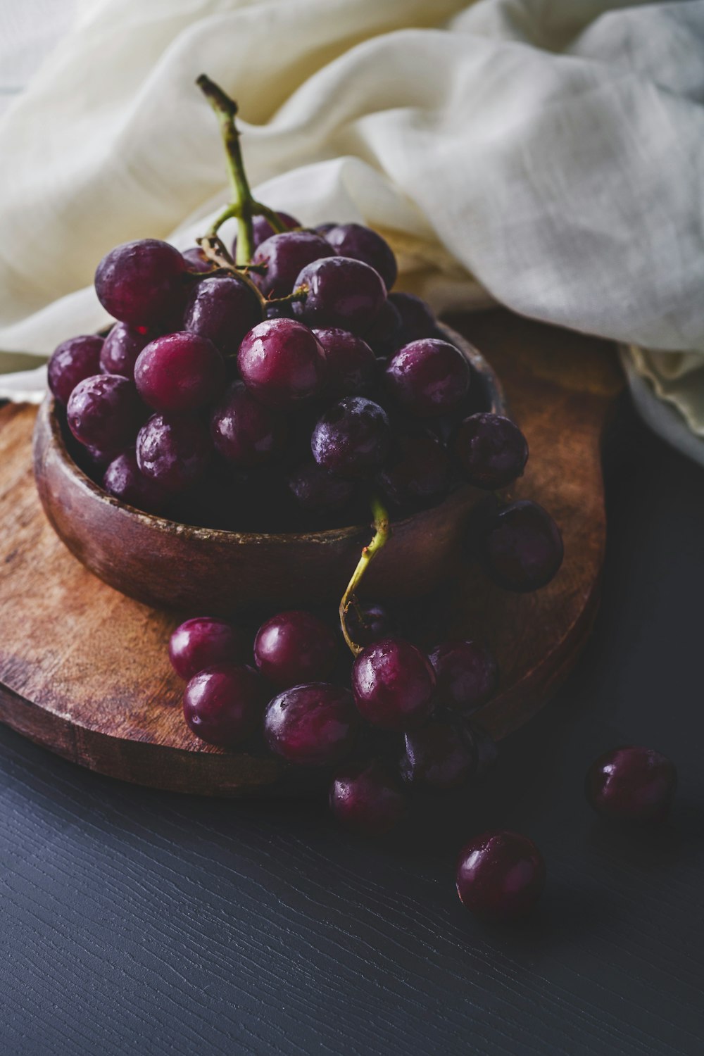 photography of red grapes on bowl
