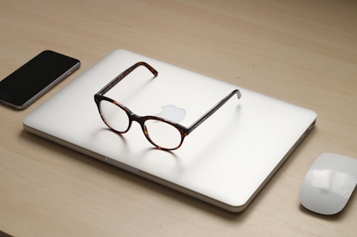 tortoiseshell framed sunglasses on silver MacBook