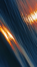 a blurry photo of the sun setting over a body of water