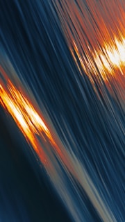 a blurry photo of the sun setting over a body of water