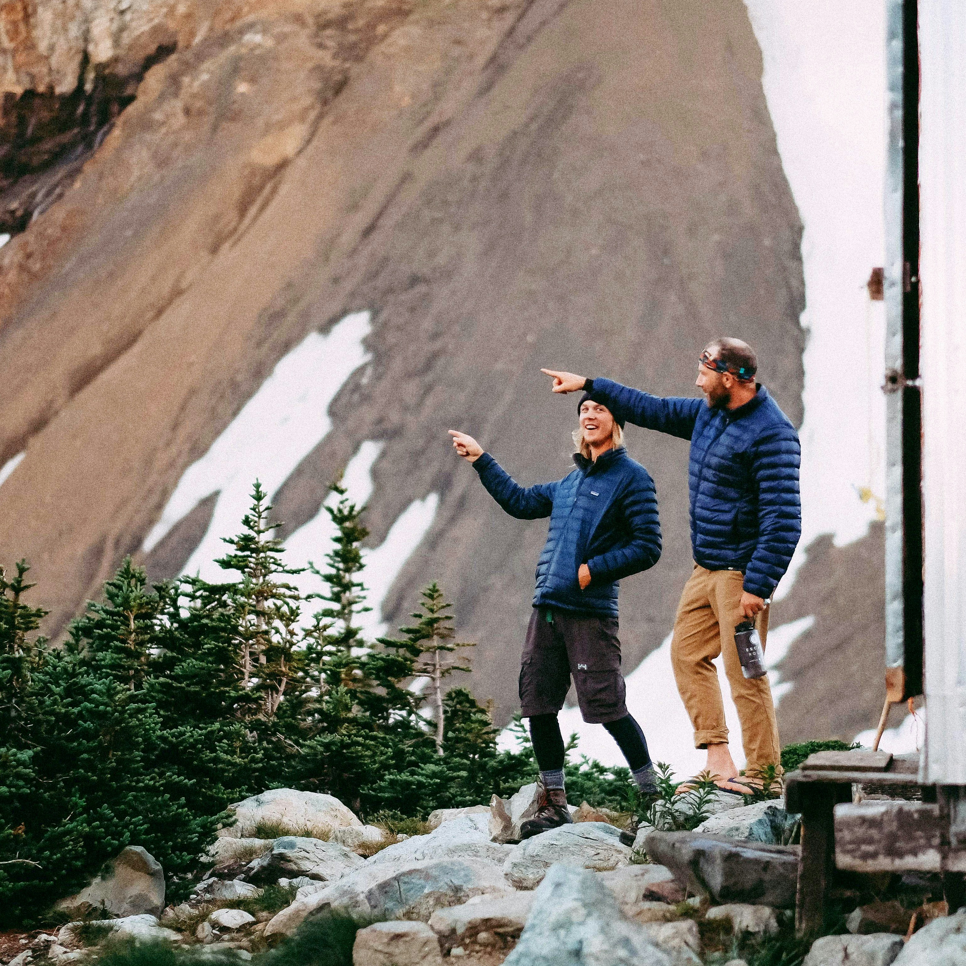 two men standing on rock