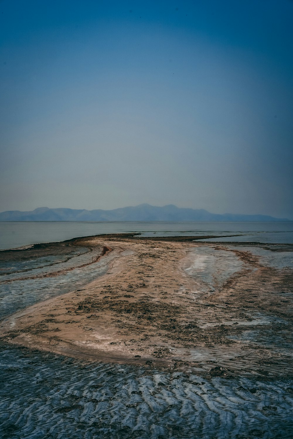 brown sand near body of water during daytime