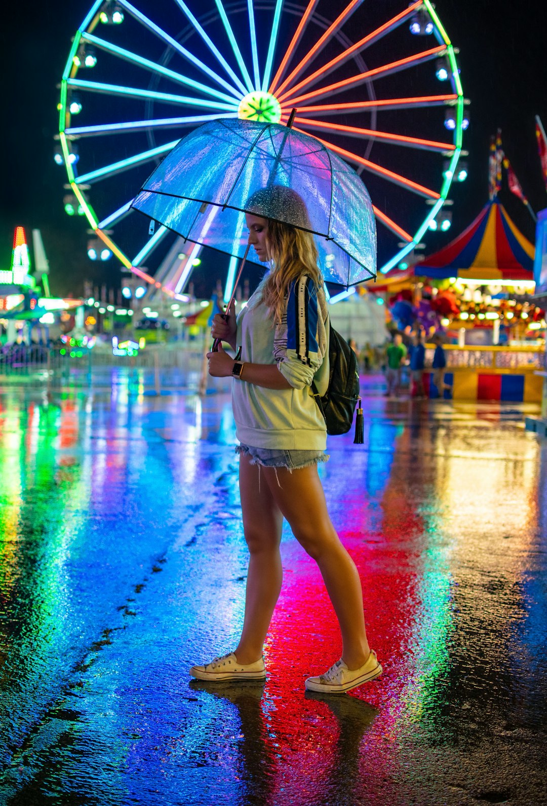 woman walking on pavement holding umbrella