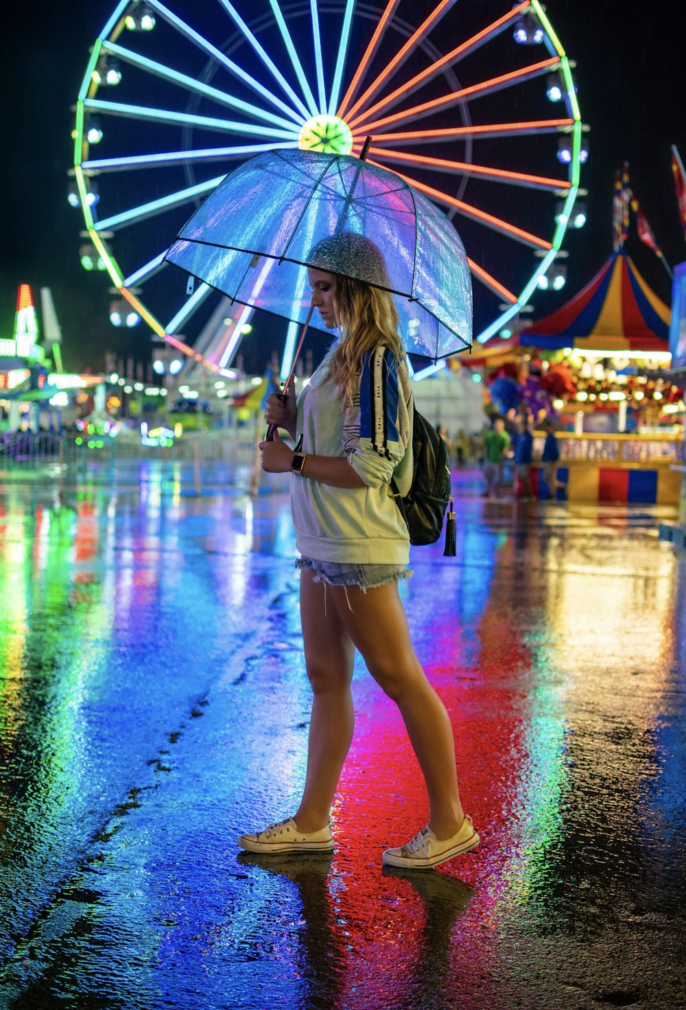 Mujer caminando sobre el pavimento sosteniendo un paraguas