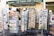 Outside a shop named 'Le Vieil Aix Cadeaux,' various racks display colorful postcards and greeting cards. The racks are filled with images of local landscapes, historical sites, and cultural art. A sign advertises a price for the items, and the shop's green awning is visible above.