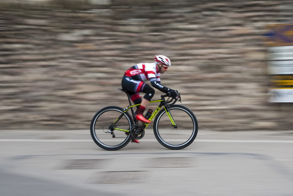 man riding green and black road bike during daytime