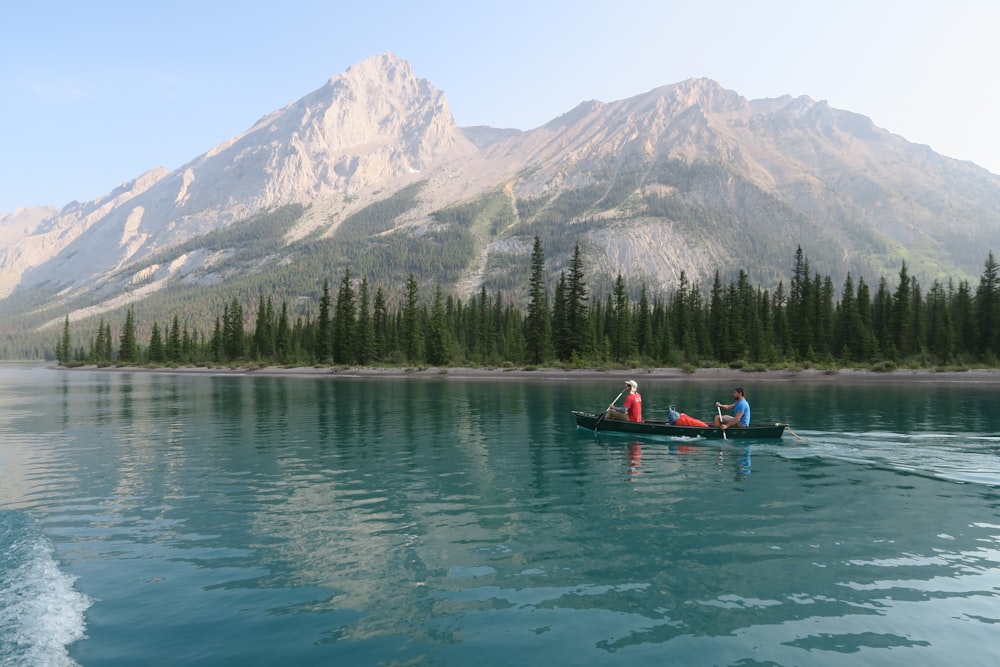 two person riding brown boat on body of water