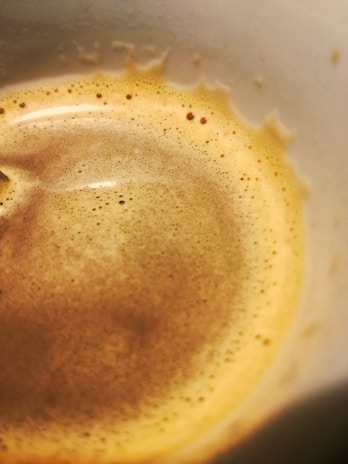 Close-up of a steaming cup of South Indian filter coffee with frothy top.