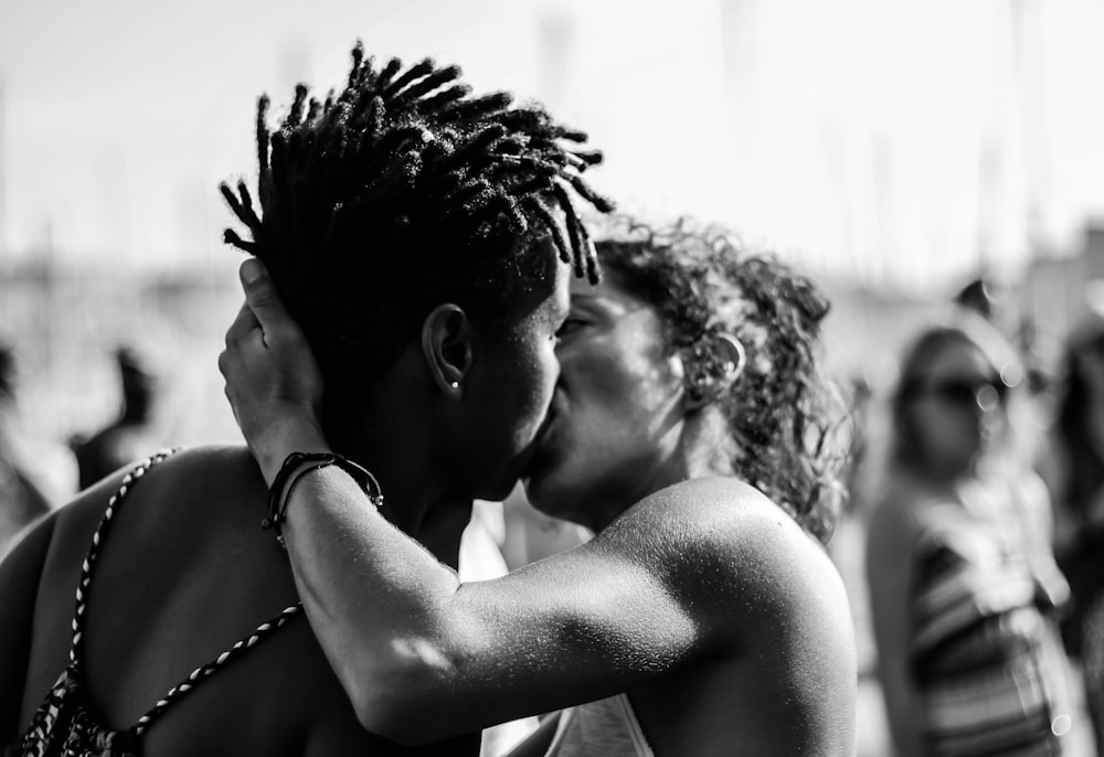 fotografia em tons de cinza do homem e da mulher se beijando