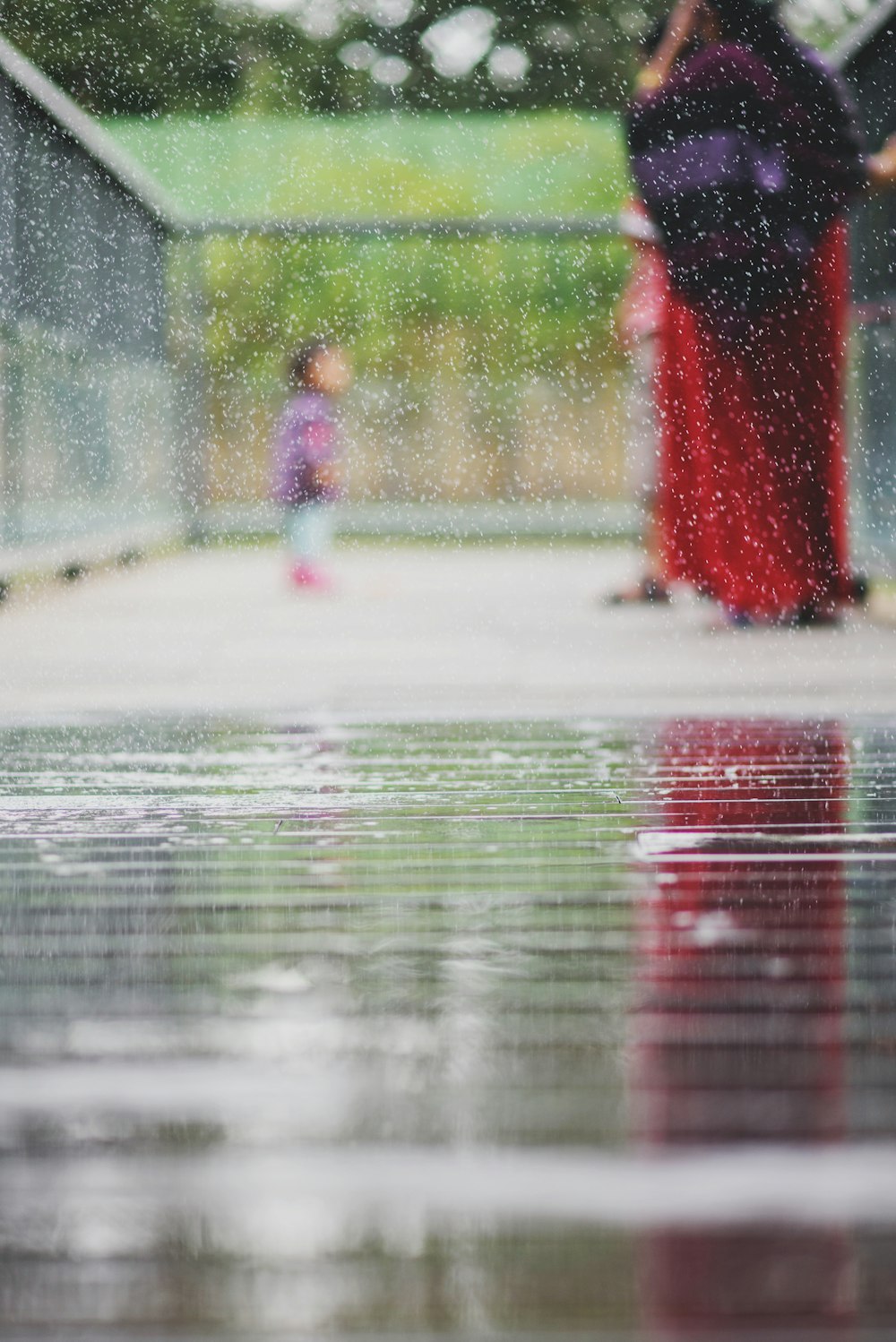 toddler standing near woman in red dress