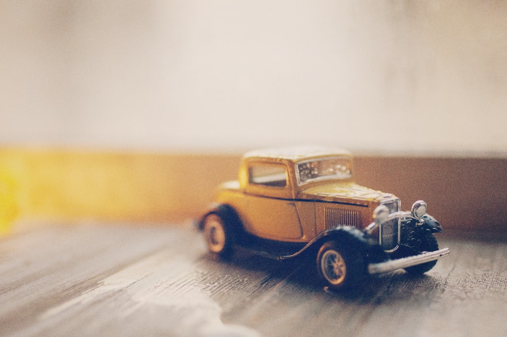 selective focus photography of classic brown coupe die-cast model on gray ground