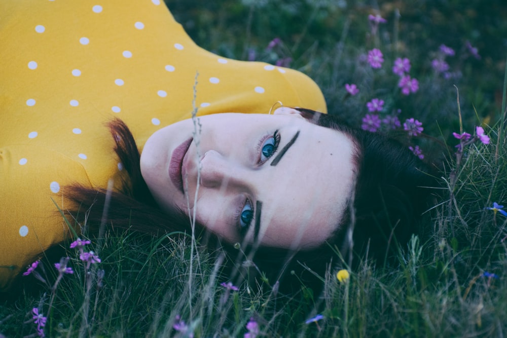 woman lying on green grassy field