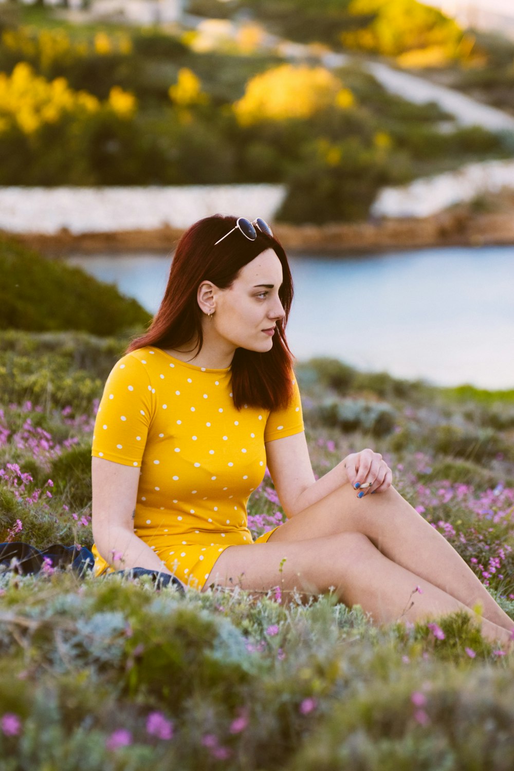 woman sitting on green grass while looking sideways