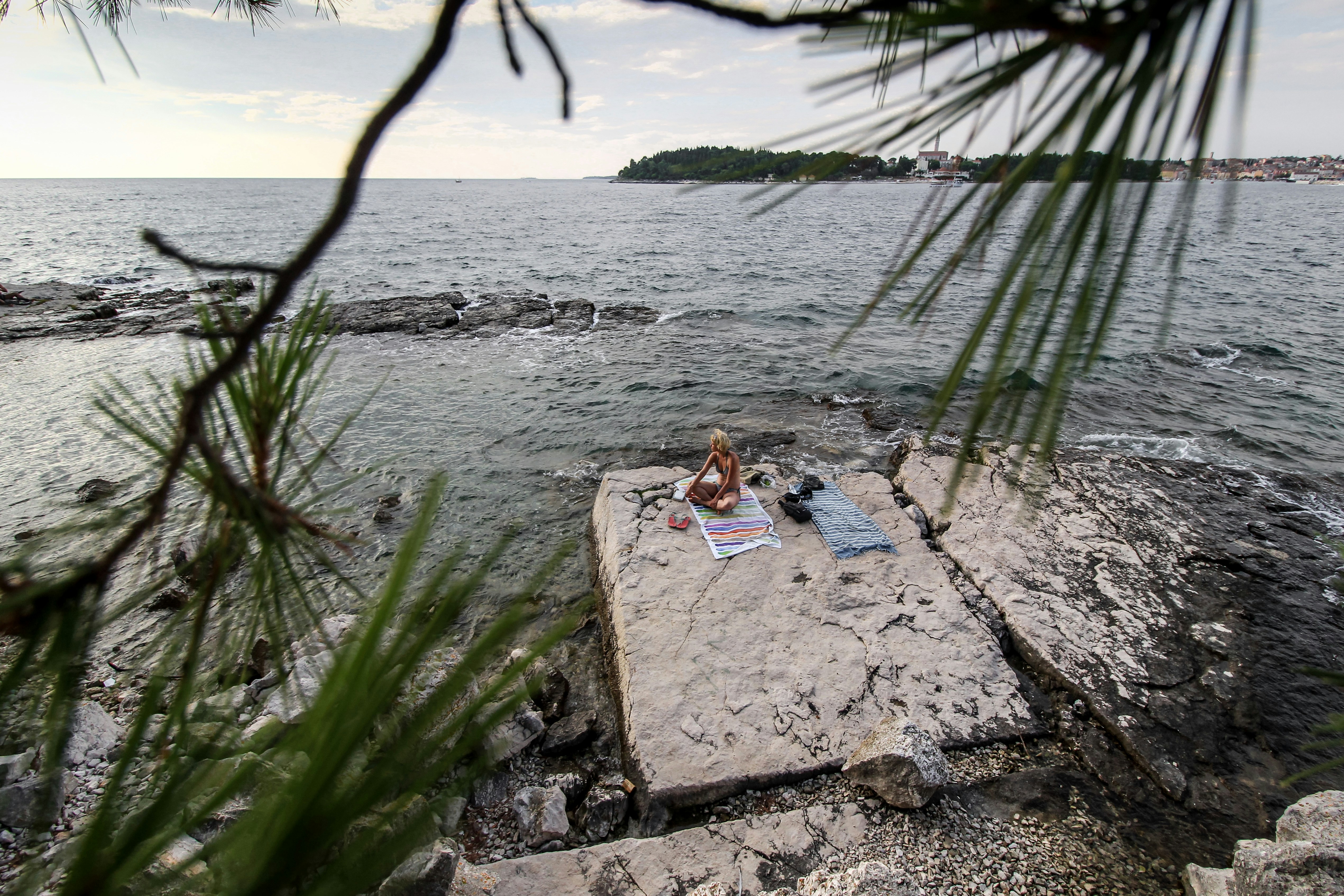 woman sitting on seashore, Rovinj, Istria, offers some of the most beautiful rocky beaches on the coastline of the Adriatic Sea.</p><p>Shot by > www.instagram.com/valentinsalja
