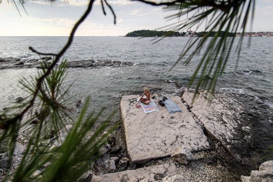 woman sitting on seashore in Rovinj Croatia