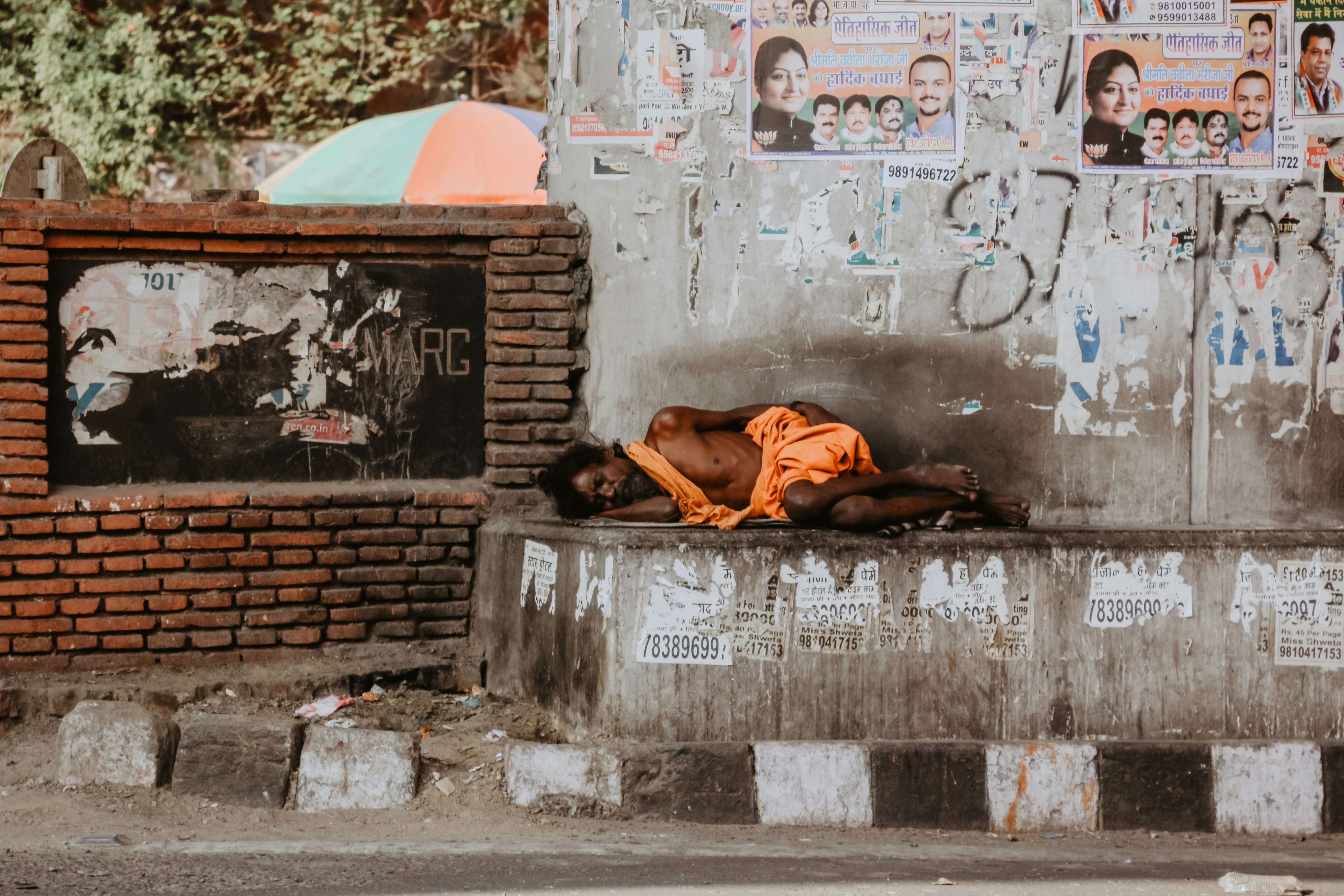 man lying on gray concrete road during daytime