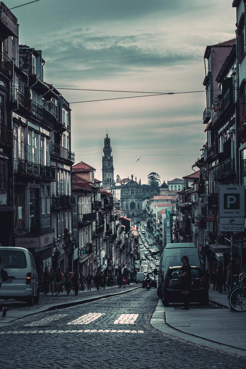 people standing on road between houses