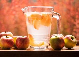 glass pitcher and apples on table