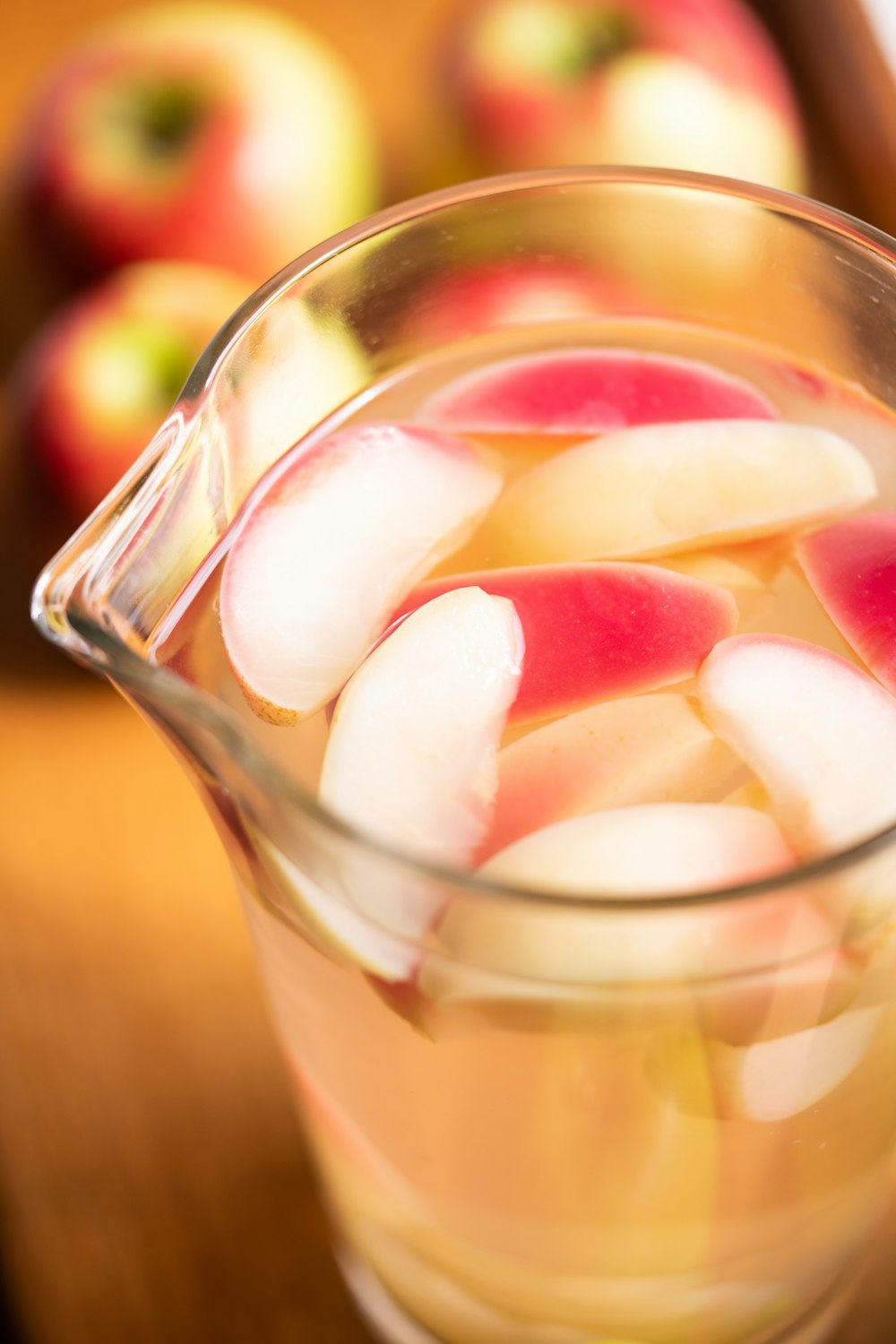 Pichet en verre transparent à côté de la pomme