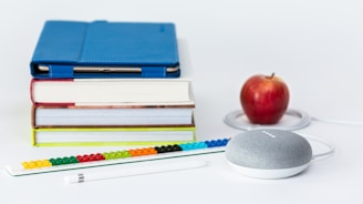 honeycrisp apple fruit near books and chalk Google Home Mini smart speaker