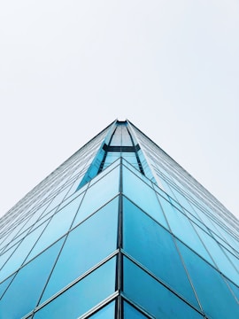 a very tall glass building with a sky background