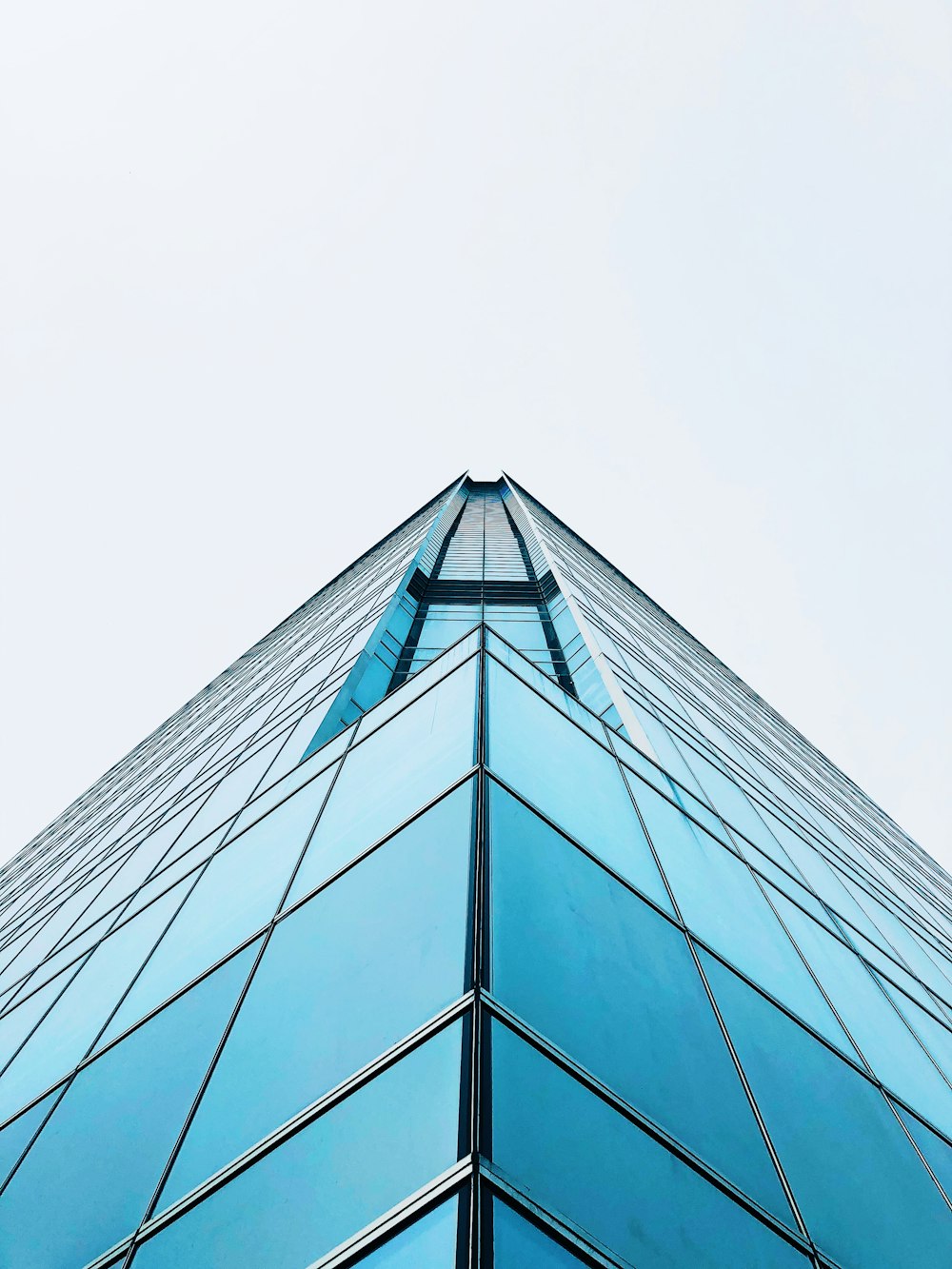 a very tall glass building with a sky background