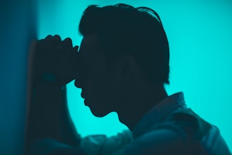 man standing against a wall in distress