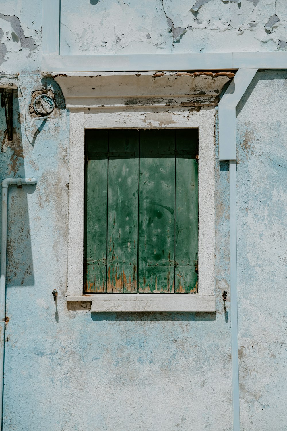 a blue building with a window and bars on it