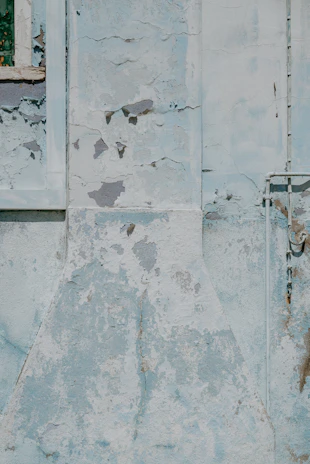 Detail of chipped paint around window frames on a residential building.