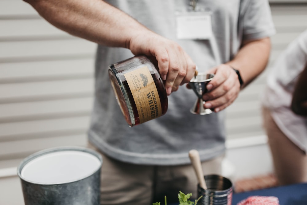 person pouring whiskey on goblet