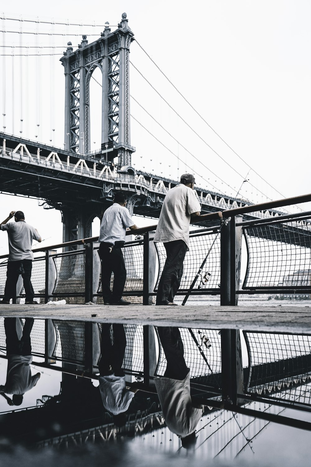 three men standing near bridge