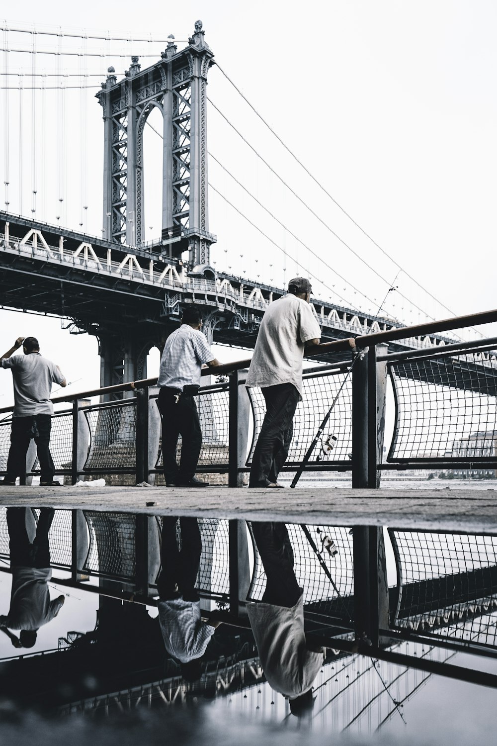 Drei Männer stehen in der Nähe der Brücke
