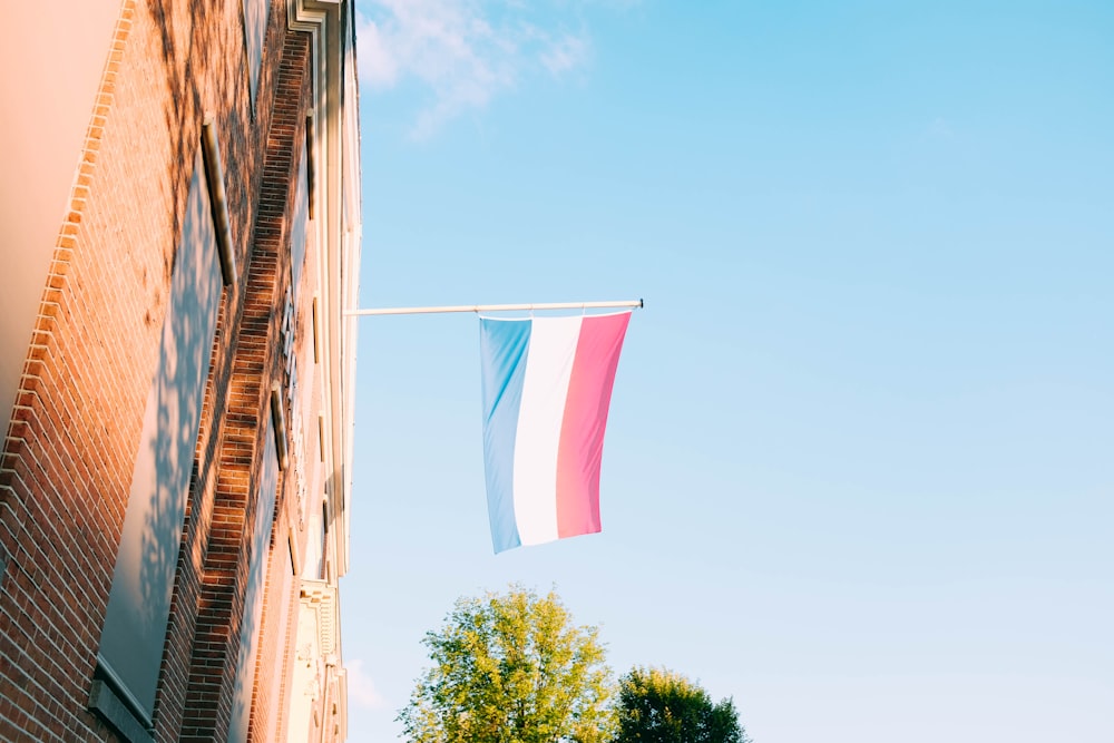 red, white, and blue flag hanging on window