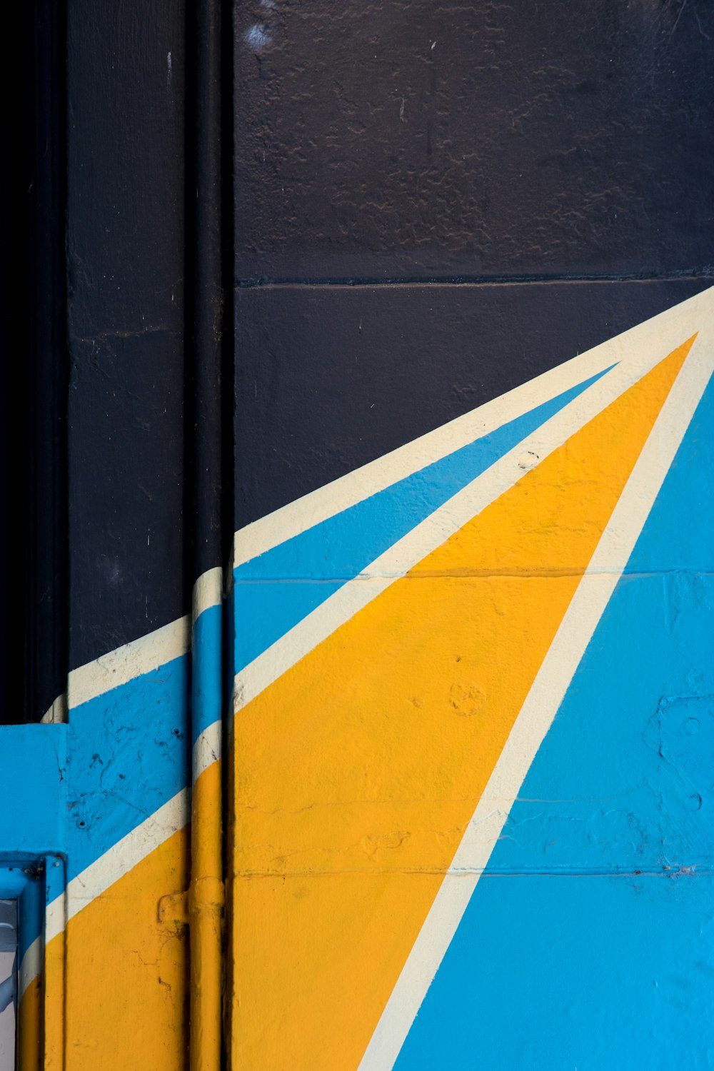white, blue, and yellow mural painted on building wall
