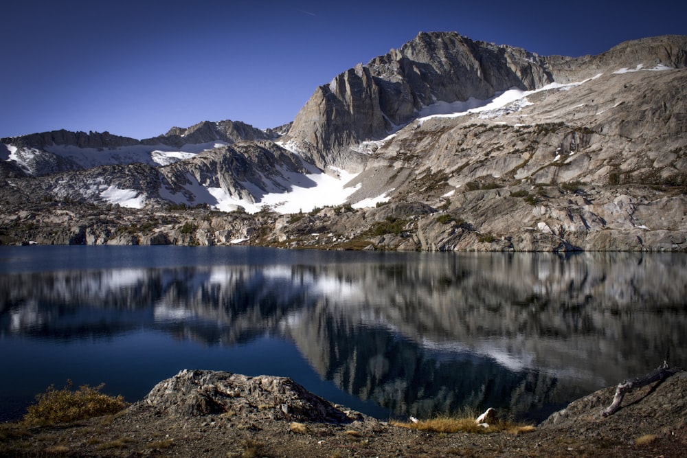 reflection photography of body of water and tundra mountain