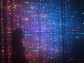 person standing in front of beaded lighted curtains