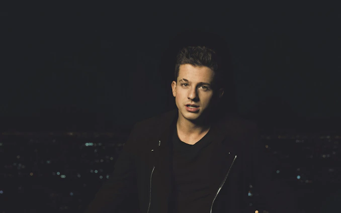 A moody, cinematic shot of a young person wearing époque noire streetwear against an urban night backdrop.