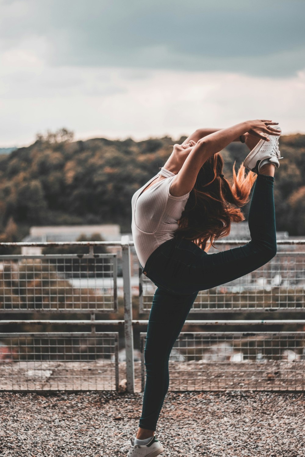 woman making stunts near white grilles