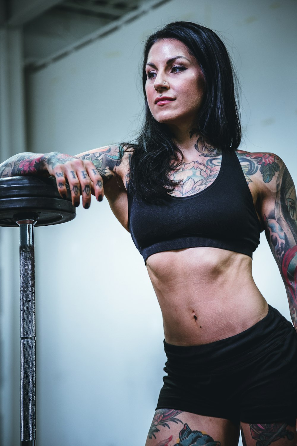 woman leaning on black steel barbell