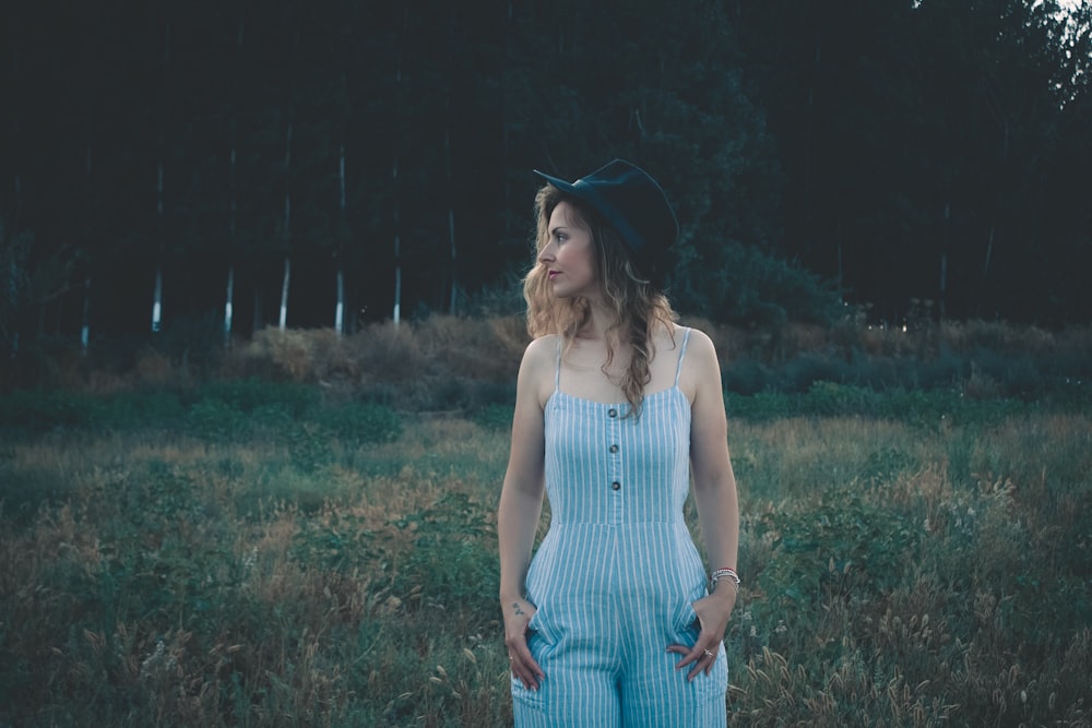 woman standing near green grass lawn during daytime showing her cheek