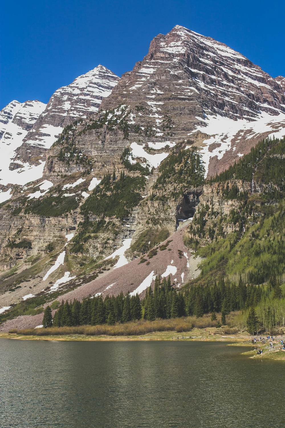 aerial photography of wide river leading to mountain under clear blue sky