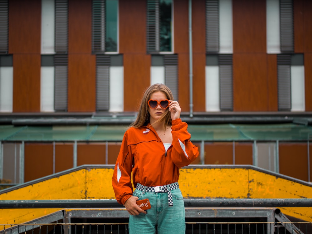 woman standing beside grill while holding sunglasses