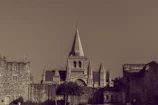A sepia-toned photograph of Diegem's Sint-Catharinakerk from the early 1900s, framed by aged trees.