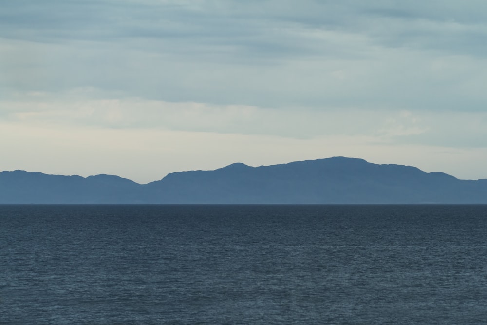 sea near mountain at golden hour