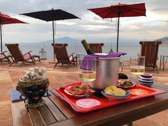 A rustic table set with Mediterranean tapas and bottles of local wine, framed by the sea horizon.