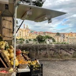 A vibrant farm stand bursting with colorful fresh vegetables and fruits under a sunny sky.
