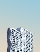 Wide shot of a high-rise building facade featuring large glass panels with subtle gradient tint.