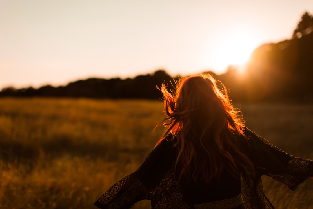 woman standing on grass field, Go wild for this moment. Be happy for this moment. This moment is your life.