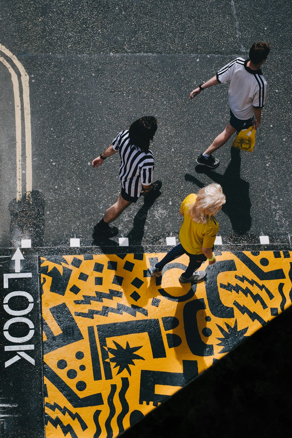 three people walking on road