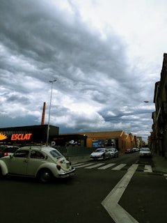 A bustling Detroit street scene with vintage cars and brick factories under a cloudy sky.